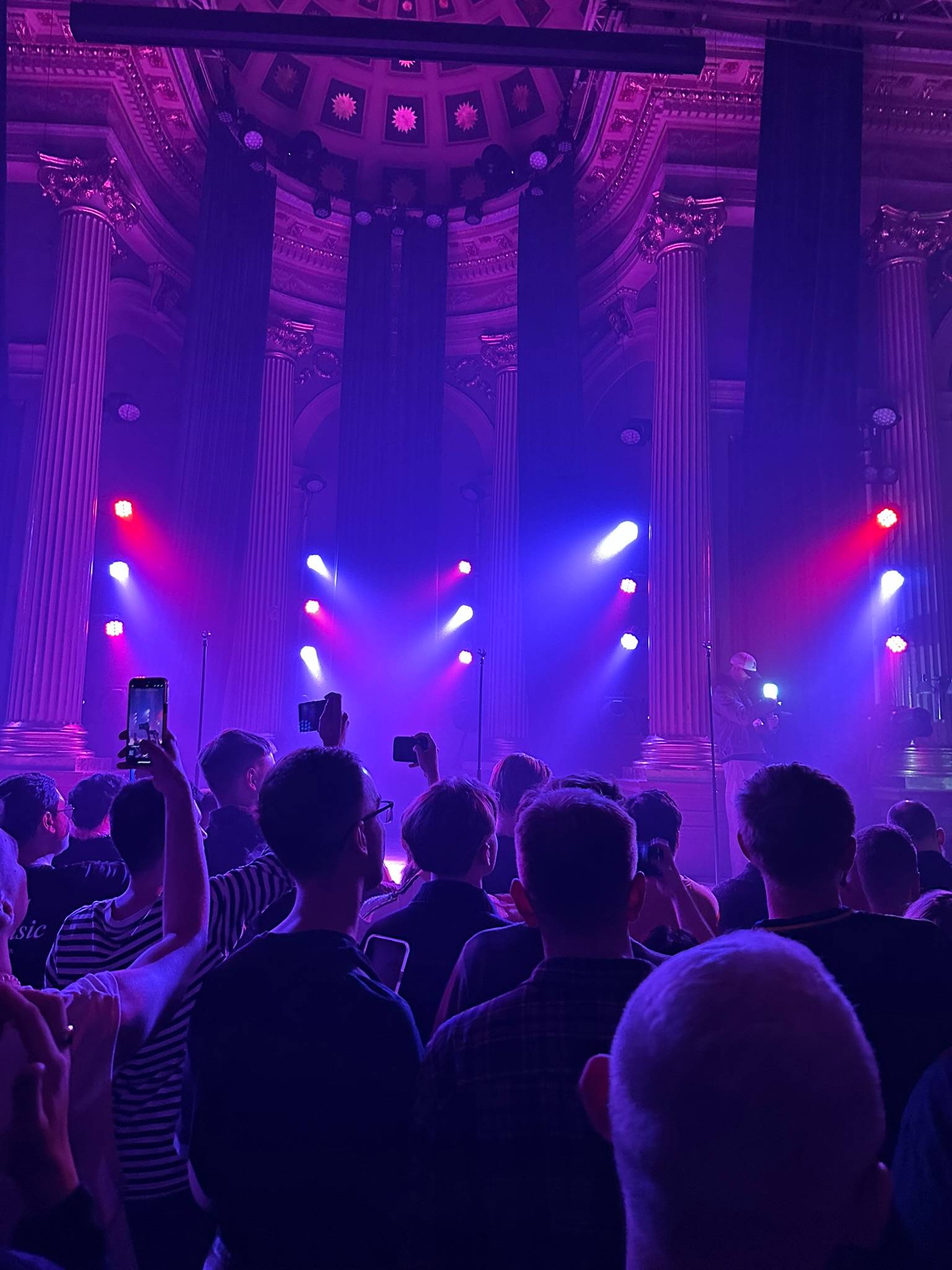 Publik i en salong i lila scenljus